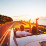 Happy couple driving on country road